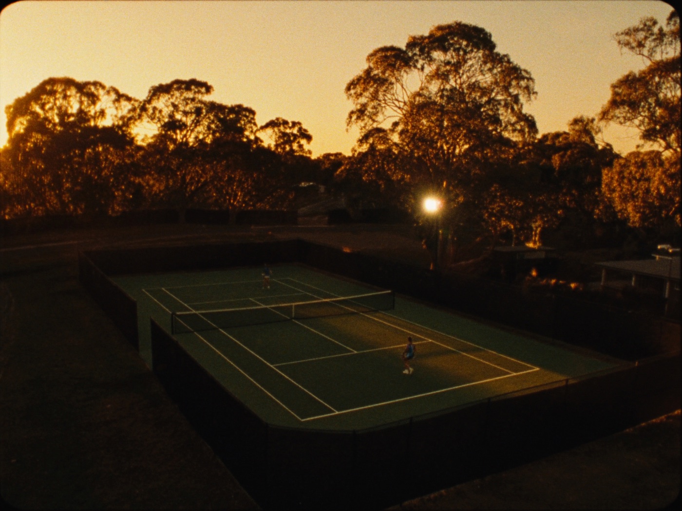 A suburban court glowing under its lights at golden hour